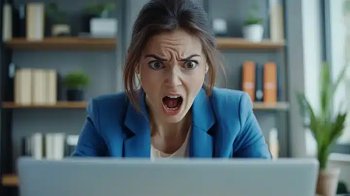 Shocked woman looking at a computer screen.